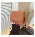 Detail of warm brown woven texture shoulder bag with Fashion Trend slogan on flap - Brown