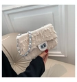 Close-up of beige textured fabric shoulder bag with fringe detail and silver chain - Beige