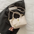Beigefarbene Beuteltasche mit Litschi-Struktur, Goldverschluss und Hasenanhänger - Weiß