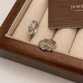 Detailansicht der silbernen Knotenohrringe mit glitzerndem Zirkonia in einer Schmuckschatulle - Knoten Pave Zirkonia Stil / Silber