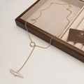 Detailopname van gouden Y-vormige ketting met barokke parel op een linnen juwelendia - Gouden Barok Zoetwaterparel Hanger Ketting