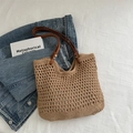 Gehäkelte Tragetasche in Hellbraun mit Ledergriffen auf Denim-Hintergrund - Khaki