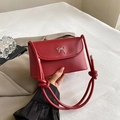 Vibrant red leather flap bag featuring a silver metal bow and knotted shoulder strap - Matte Red