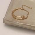 Close-up of golden double-layer interwoven bracelet with adjustable chain on a tray - Gold