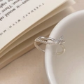 Detalle de anillo de mariposa plateado con perlas y cristales en una taza blanca - Plateado