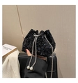Detail of black sequin bucket bag featuring silver chain and large pearl drawstring accents - Black