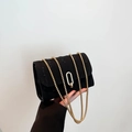 Chic black textured crossbody bag with gold chain strap and oval metal buckle - Black