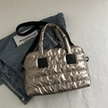 Borsa tote trapuntata argento con manici neri presentata in un contesto casual - Oro