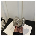 Detailed view of a silver shell-shaped metallic clutch bag with a sleek snake chain strap - Silver Conch