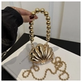 Detailed view of a golden shell-shaped evening clutch bag with metal bead handles - Shell Inlay Gold Color