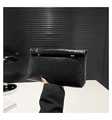 Vista dettagliata della pochette nera intrecciata con fibbie dorate ed eleganti - Nero