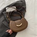 Bolso de hombro marrón con hebilla de luna dorada sobre una chaqueta gris - Marrón