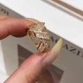 Detailaufnahme eines goldenen Knotenrings mit Zirkonia-Steinen und Webstruktur - Gold
