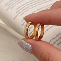 Gros plan de boucles d'oreilles créoles dorées avec zircons sertis en forme d'étoile - Boucles d'Oreilles en Zircone Design Unique Doré