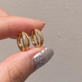 Close-up of geometric double-layer gold hoop earrings featuring micro-set zircon accents - Gold