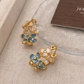 Close-up of gold-plated flower earrings with blue and white enamel petals and small crystal - Blue Flower Ear Buckle / Blue/Gold