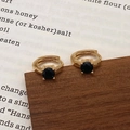 Détail de créoles dorées ornées d'un zircon noir classique avec sertissage à quatre griffes - Boucles d'oreilles en or avec zircon noir