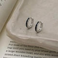 Detail van zilveren oorringen met zwart emaille inleg op een vintage keramisch bordje - Zilver Zwart Emaille Stijl