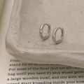 Detail van zilveren oorringen met vierkante zirkoon op een getextureerde keramiek - Zilver Vierkante Zirkonia Stijl