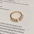 Detaillierte Makroansicht des Vintage-Goldrings mit acht Perlen und Zirkonia-Akzenten - Goldner Perlen Zirkon Verstellbarer Ring