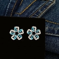 Macro view of flower-shaped blue zircon earrings with sparkling white stone petals - Aqua