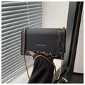 Detalle de bolso bandolera de leopardo con cadena dorada e inscripción de moda - café