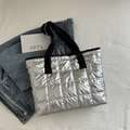 Sac cabas matelassé argenté moderne avec larges anses noires sur fond de jean - Argenté