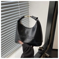 Detalle de bolso medialuna negro con letras grabadas y hebilla de metal dorada - Negro