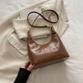Bolso hobo de cuero marrón brillante con herrajes dorados y detalles grabados - Marrón