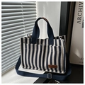 Detalle del bolso tote de lona a rayas con bolsillos frontales y etiqueta de cuero - Azul