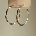 Detalle de aros grandes plateados con diseño retorcido exclusivo y poste de plata S925 - 4cm / Plateado