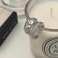 Detail of silver ear cuffs set with hammered texture and pave cubic zirconia on a white candle - Micro Pave Zircon Silver Ear Cuff
