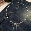Dettaglio di una collana di perle stile francese con ciondolo a fiocco fatto a mano - Perla Bianca