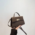 Donkerbruine suède crossbody tas met goudkleurige draaisluiting en smalle riem - Bruin