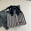 Borsa tote in tela a righe blu e bianche con etichetta in pelle marrone e tracolla - Blu