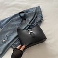 Chic black hobo shoulder bag with silver buckle on denim jacket background - Black