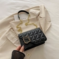 Borsa a tracolla trapuntata nera con fibbia dorata su un elegante blazer beige - Nero