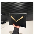 Detail of black envelope clutch featuring gold V-shaped metal trim and chevron stitching - Black