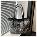 Detail der grau-schwarzen Totebag mit Leopardenmuster, Trägern und Markenetikett - Grau