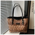 Detaillierte Nahaufnahme der Leopard-Tasche mit schwarzen Griffen und Metallnieten-Details - Braun