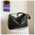 Close-up of minimalist black leather hobo bag with adjustable strap on white pedestal - Black