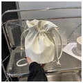 Vista detallada de un bolso bombonera crema con cordón y textura plisada en estante - Blanco