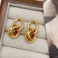 Detail von ineinandergreifenden goldenen geometrischen Ohrringen mit Polierung - Creolen / Gold
