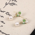 Dettaglio di orecchini di perle con fiore di trifoglio bianco e piccoli accenti verdi - Fiore Verde