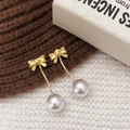 Elegant gold bow earrings with dangling white pearls on soft textured fabric background - Gold White Pearl Style (A-1122)