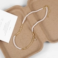 Detail of pearl necklace with irregular gold branch links on a textured eco tray - Gold