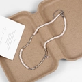 Detail of pearl necklace with irregular silver branch-shaped metal on pulp packaging - Silver
