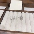 Detailed view of silver triple-row zircon stud earrings on a wooden jewelry display - Silver