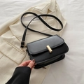 Classica borsa a tracolla quadrata nera con chiusura dorata su blazer crema - Nero