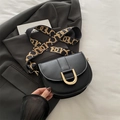 Black leather saddle bag with gold U-buckle and patterned wide shoulder strap - Black
